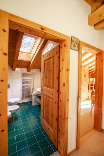 a bathroom with wooden doors and a green floor at Chalet Gulas - La Punt-Chamues-ch in La Punt-Chamues-ch