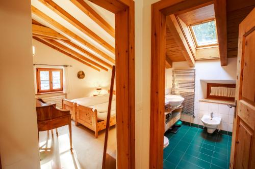 a bathroom with a bed and a sink in a room at Chalet Gulas - La Punt-Chamues-ch in La Punt-Chamues-ch