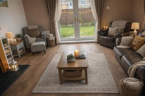 a living room with a couch and a table at Christinas Cottage Downpatrick in Raholp