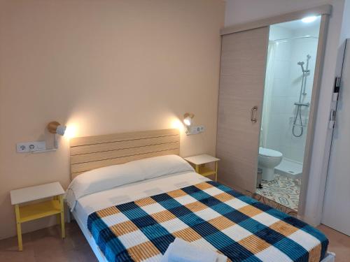 a bedroom with a bed and a bathroom with a shower at Alcazaba Home in Almería