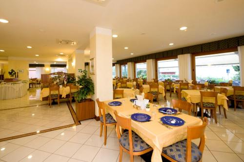 a dining room with tables and chairs in a restaurant at Hotel Astoria - 3stelle S in Malcesine