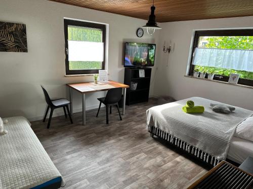 a bedroom with a bed and a desk and a table at Zimmer, Apartment A3 in Offenberg