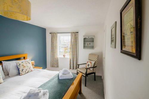 a bedroom with a bed and a chair and a window at Chapel Bricks in Withernwick