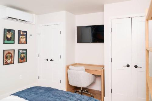 a bedroom with a bed and a desk and a tv at Pint-Sized on Poplar in Cambridge