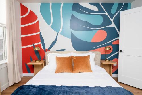 a bedroom with a bed with a colorful wall at Pint-Sized on Poplar in Cambridge