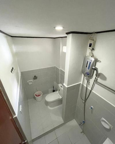 a small bathroom with a toilet and a shower at Hiddennest Guest house in Alcantara