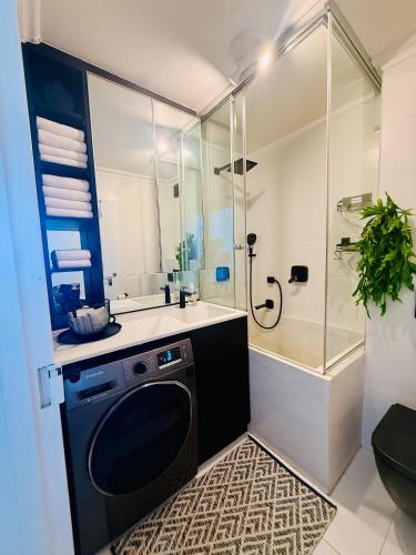 a bathroom with a washing machine and a shower at Deja Blue in Westbrook