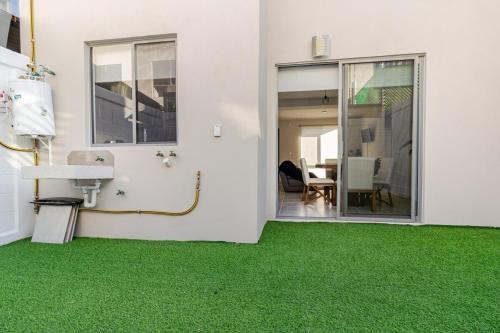 a room with green carpet and a sink and a table at Casa Brianzzas in Miranda