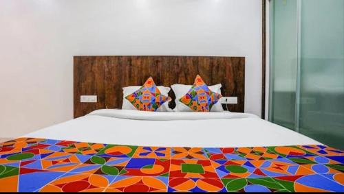 a bedroom with a bed with a colorful comforter at Hotel Krishna Inn in Bhiwandi