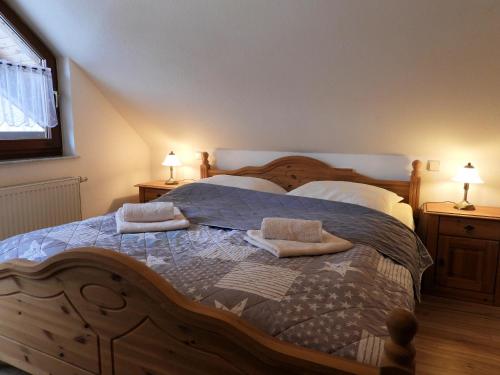 a bedroom with a large wooden bed with pillows at Auf der Heide - Ferienhaus für 6 Personen in Borkheide