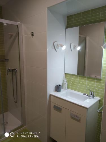 a bathroom with a sink and a shower with a mirror at Casa Pura in Ribadeo