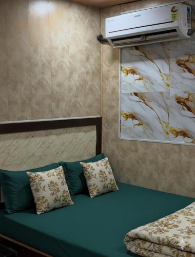 a bedroom with a bed with pillows and a painting at Hotel Al Mehraj in Mumbai