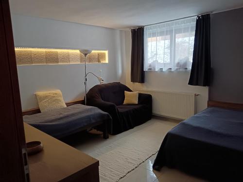 a living room with a couch and a chair at Káli Apartman in Bakonybél