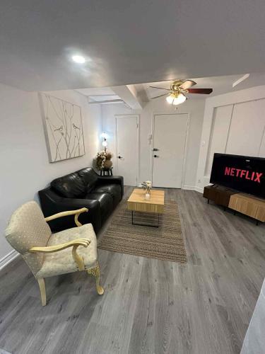 a living room with a black leather couch and a table at Lovely apartment for rent in Vitry-sur-Seine