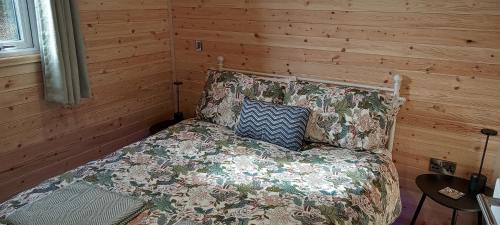 a bedroom with a bed in a room with wooden walls at Foxwell in Ballina