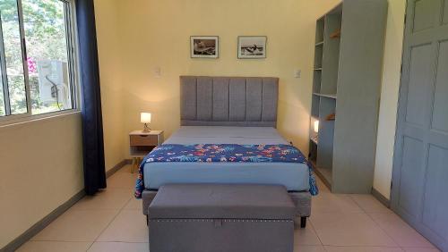 a small bedroom with a bed and a window at Villas Pura Vida - Guapinol in Río Negro