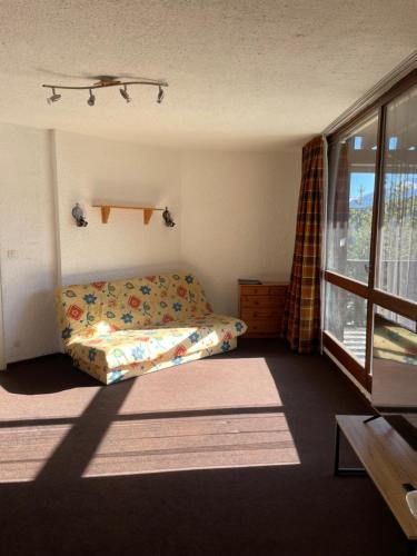 a small bedroom with a bed and a window at T2 Praloup 1500 in Uvernet