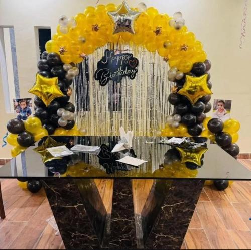 a table with yellow and black balloons and a starvisor at Lallan Top Hotel in Unnāo