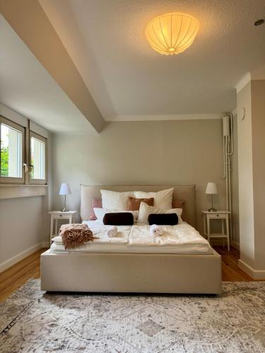 a bedroom with a large white bed with two tables at Boutique Apartment Villa Jaenisch in Kaiserslautern