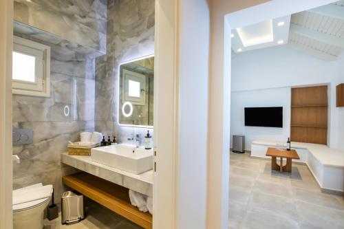 a bathroom with a sink and a toilet and a mirror at Manos Villas in Karpathos
