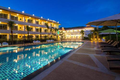 una piscina frente a un hotel por la noche en Villa Blanca Hotel & Restaurant en Chao Lao Beach