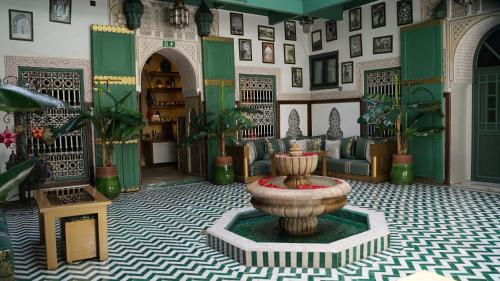 a room with a fountain in the middle of a room at Riad Les Oliviers & Spa in Marrakesh