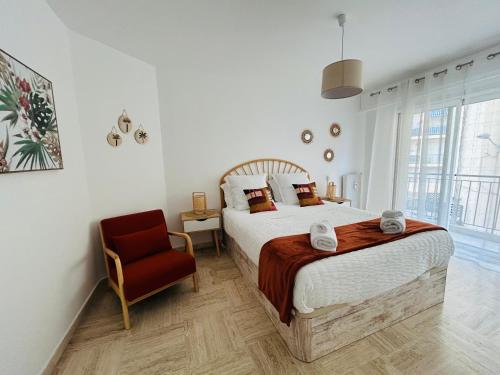 a bedroom with a large bed and a chair at Appartement Spacieux au Port de Nice avec Clim et Parking Gratuit in Nice