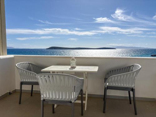 a table and chairs on a balcony with the ocean at Kleanthi Apartments in Drios
