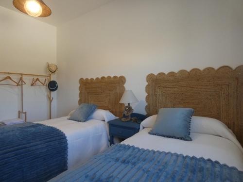 a bedroom with two beds with blue pillows at El Refugio de Hugo in Caravaca de la Cruz