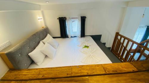 a bedroom with a large bed with white sheets and pillows at Coco Wave Midigama in Midigama East