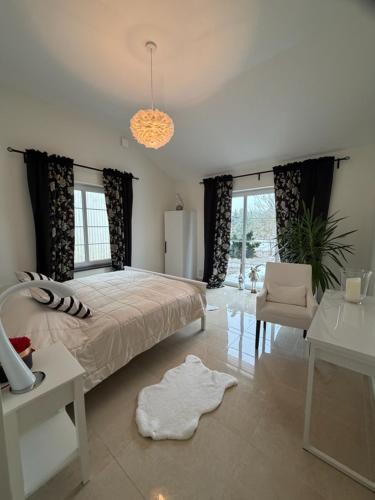 a bedroom with a large bed and a table and chair at Eden-Dom Wakacyjny z Domkiem Gościnnym in Trelleborg