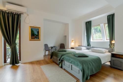 a bedroom with two beds and a table and chairs at Pension Casa Vanatorilor in Băile Olăneşti