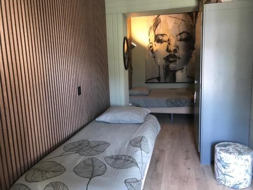 a small room with two beds and a painting on the wall at Klein Haasdal Studio's in Schimmert