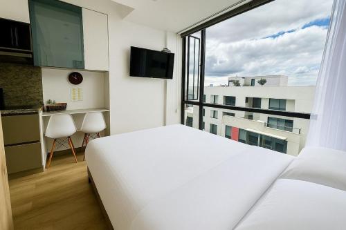 a bedroom with a white bed and a large window at Exclusive Tiny Loft in Usaquén in Bogotá