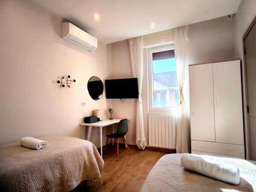 a bedroom with two beds and a desk and a window at Dolce 2 bedrooms Apartment Milano 2mins to Rho Fiera & 25mins to Duomo Centre & 100m to Metro in Pero