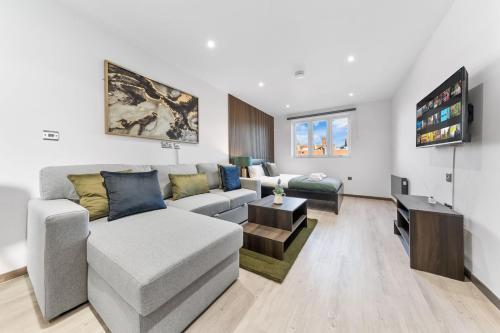 a living room with a couch and a tv at Green Studio Suite - Central London - Near Station in London