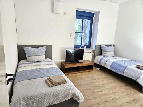 a room with two beds and a television in it at Monteur Oase Leipzig Nord in Schkeuditz