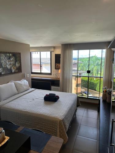 a bedroom with a large bed and a balcony at Flat Life Resort com vista do Lago in Brasília