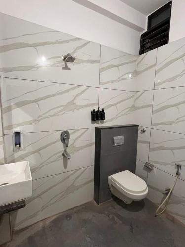 a bathroom with a toilet and a sink at ReneeMysa in Indore