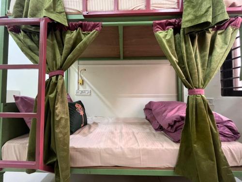 a bedroom with a bunk bed with curtains at ReneeMysa in Indore