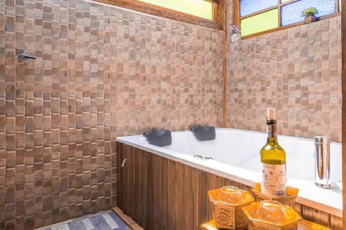 a bathroom with a tub and a bottle of wine at Hotel - Posada Las Rocas - Guasca Cundinamarca in El Lindero