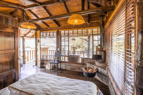 a bedroom with a bed and a large window at Hotel - Posada Las Rocas - Guasca Cundinamarca in El Lindero