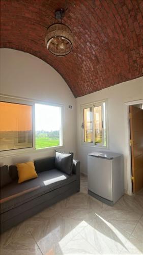 a living room with a couch and a brick ceiling at siriuspalaceluxor in Al Karnak