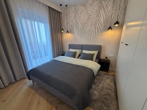 a bedroom with a bed and a large window at Apartament Kaszubska Bryza III - HEL in Hel