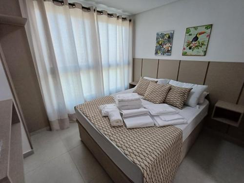 a bedroom with a bed with towels on it at Departamento ideal in Ipojuca
