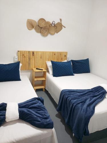 two beds in a room with blue and white at Pousada Pé no Mar in Japaratinga