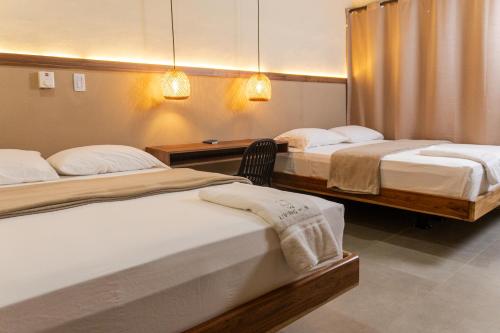 a room with two beds and a desk with two beds at The Living Hub in La Dorada