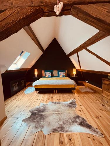a bedroom with a large bed in a attic at Gîte Origin Gueberschwihr in Gueberschwihr