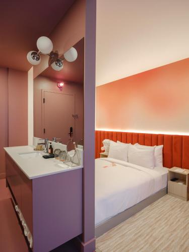 a hotel room with a bed and a sink at Rose Hôtel Invisible in Quebec City