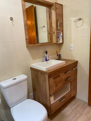 a bathroom with a white toilet and a sink at Chalé Recanto Belo. in São Mateus
